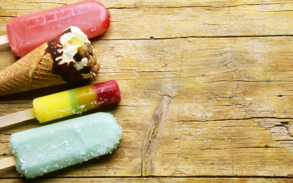 4K Ultra HD desktop wallpaper featuring colorful ice cream and popsicles on a rustic wooden surface, capturing the essence of summer food.