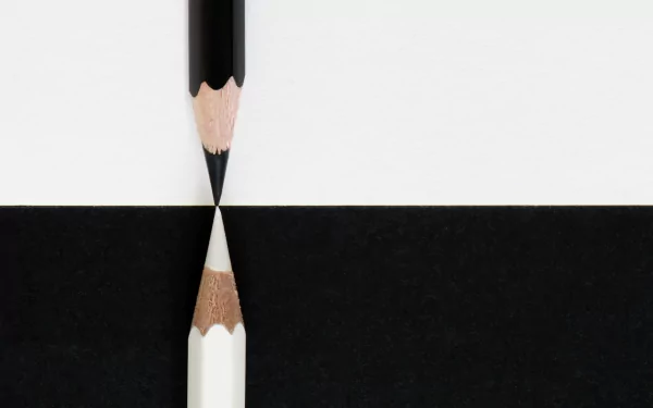 Black and white minimalist HD desktop wallpaper featuring the tips of a black and a white pencil meeting at the center, creating a striking contrast in a clean, photographic style.