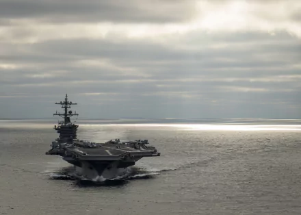 An impressive view of the USS Carl Vinson (CVN-70), a military aircraft carrier, navigating through calm waters under a cloudy sky, showcased as a high-definition desktop wallpaper.