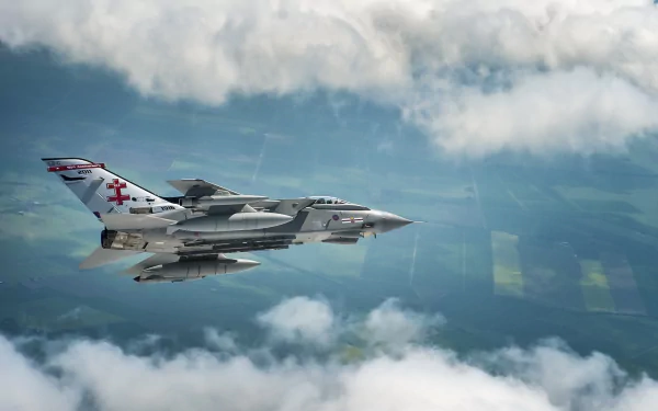 A Panavia Tornado jet fighter warplane soars through a cloudy sky, captured in high-definition as a dynamic military aircraft desktop wallpaper.