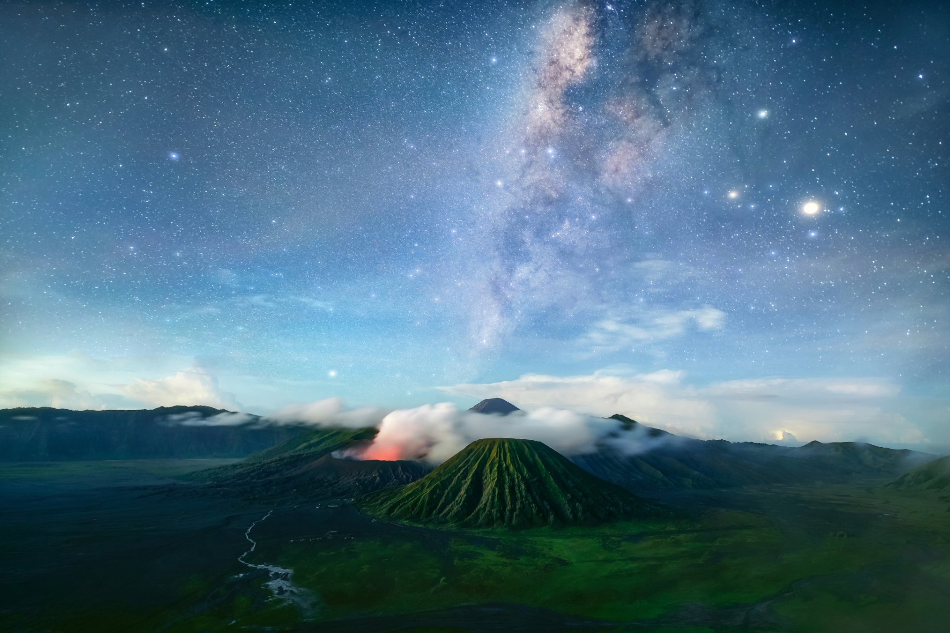 A breathtaking HD desktop wallpaper featuring a volcano under a vivid Milky Way and a starry sky, showcasing a stunning landscape of mountains and nature.