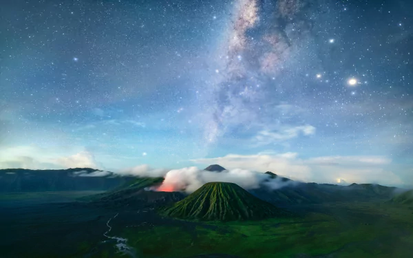 A breathtaking HD desktop wallpaper featuring a volcano under a vivid Milky Way and a starry sky, showcasing a stunning landscape of mountains and nature.