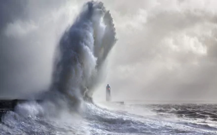 A dramatic seascape captures powerful waves crashing against a lighthouse under a stormy sky, highlighting the raw beauty of the ocean horizon in stunning HD detail.
