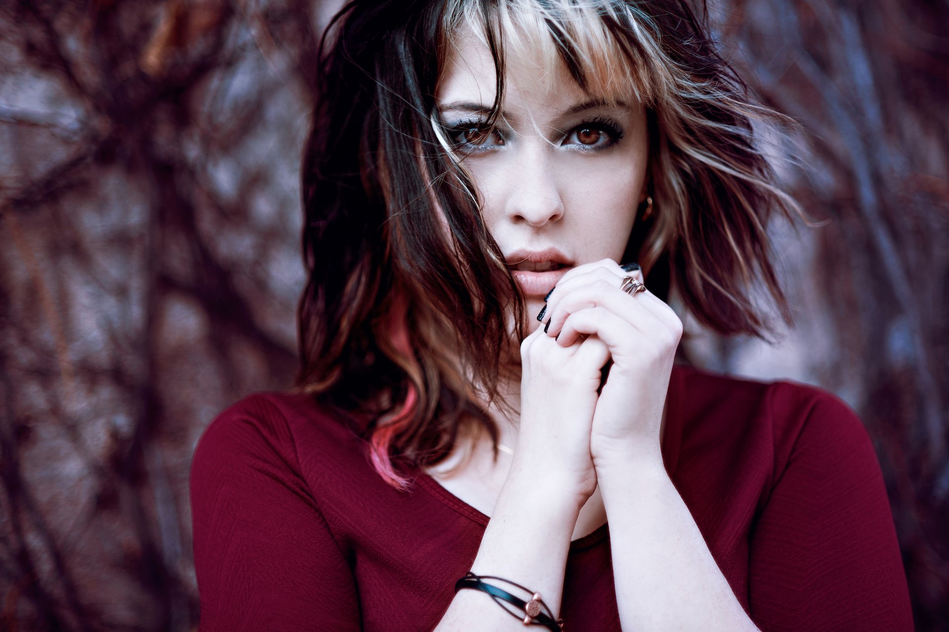 HD desktop wallpaper featuring a close-up of a brunette woman with brown eyes, softly tousled hair, and an intense, contemplative expression.