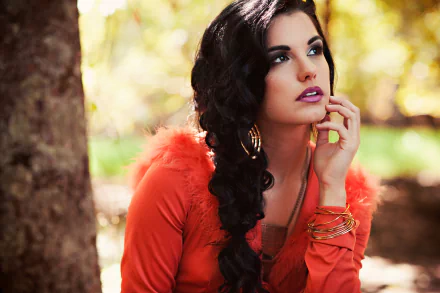 HD desktop wallpaper of a brunette woman with brown eyes and a braid, posing outdoors against a softly blurred bokeh background.