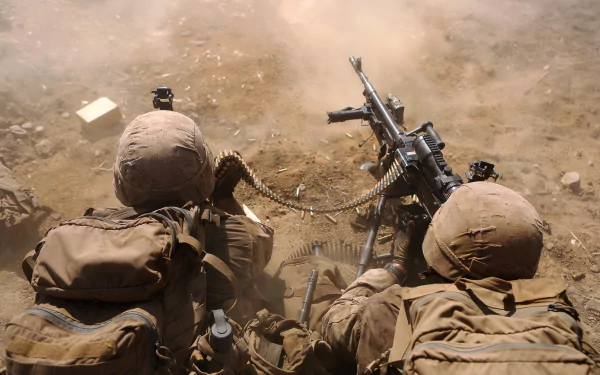 HD desktop wallpaper showing two soldiers in army gear operating a machine gun amidst a dusty, sandy military environment.