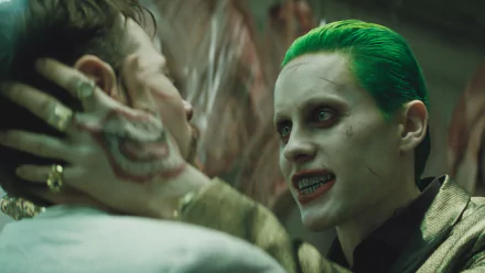 Jared Leto as the Joker in Suicide Squad, depicted in a gripping scene with intense expressions. This HD wallpaper captures the film's dark and vibrant aesthetic.