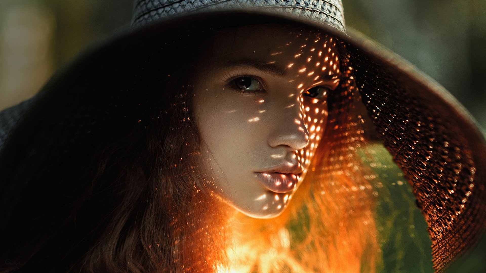 A close-up of a redheaded woman wearing a wide-brimmed hat, with sunlight casting intricate shadows on her face. This stunning image serves as a captivating HD PC desktop wallpaper.
