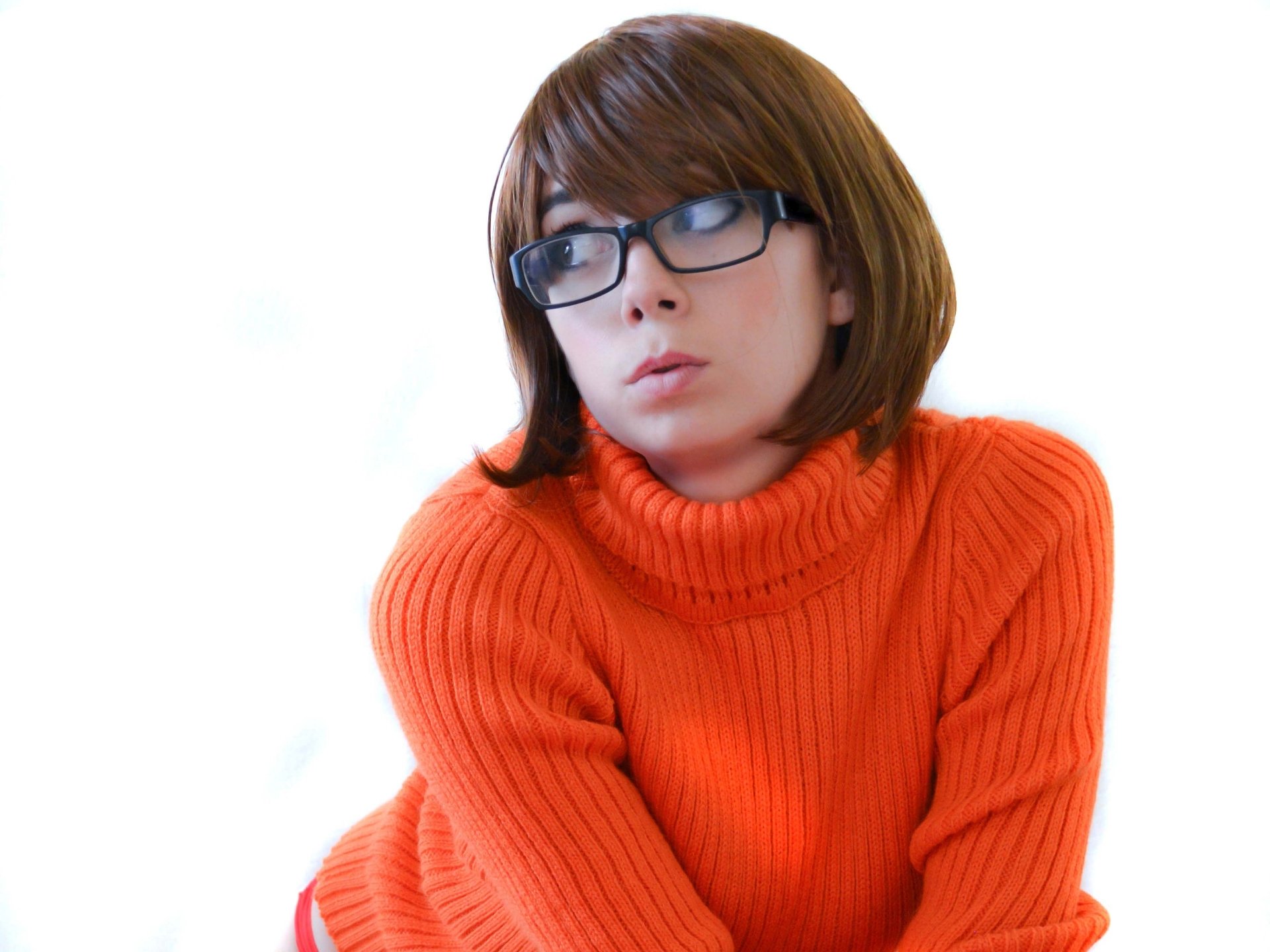 Woman in orange turtleneck and glasses, cosplay tagged 'Uncanny Megan', 2K Quad HD PC desktop wallpaper and background.