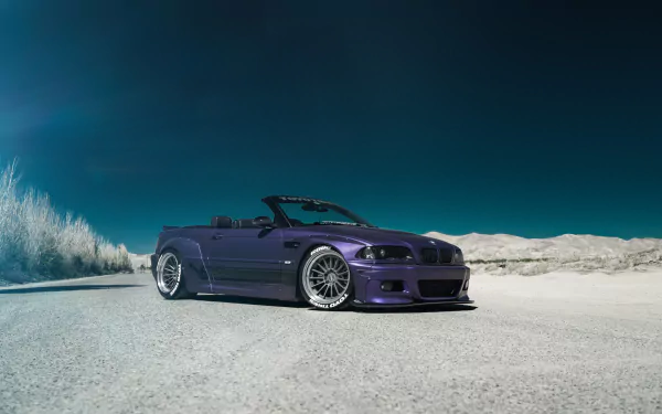 HD desktop wallpaper featuring a sleek purple BMW M3 convertible parked on a sandy terrain under a clear blue sky.