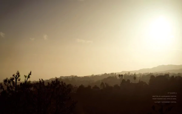 HD PC desktop wallpaper featuring a hazy sunset over a silhouetted landscape, inspired by the music and aesthetic of Nine Inch Nails.