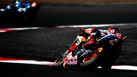 A thrilling MotoGP race scene with a rider leaning into a sharp turn on a racetrack, captured in vibrant colors. This HD image makes an engaging desktop wallpaper and background for sports enthusiasts.