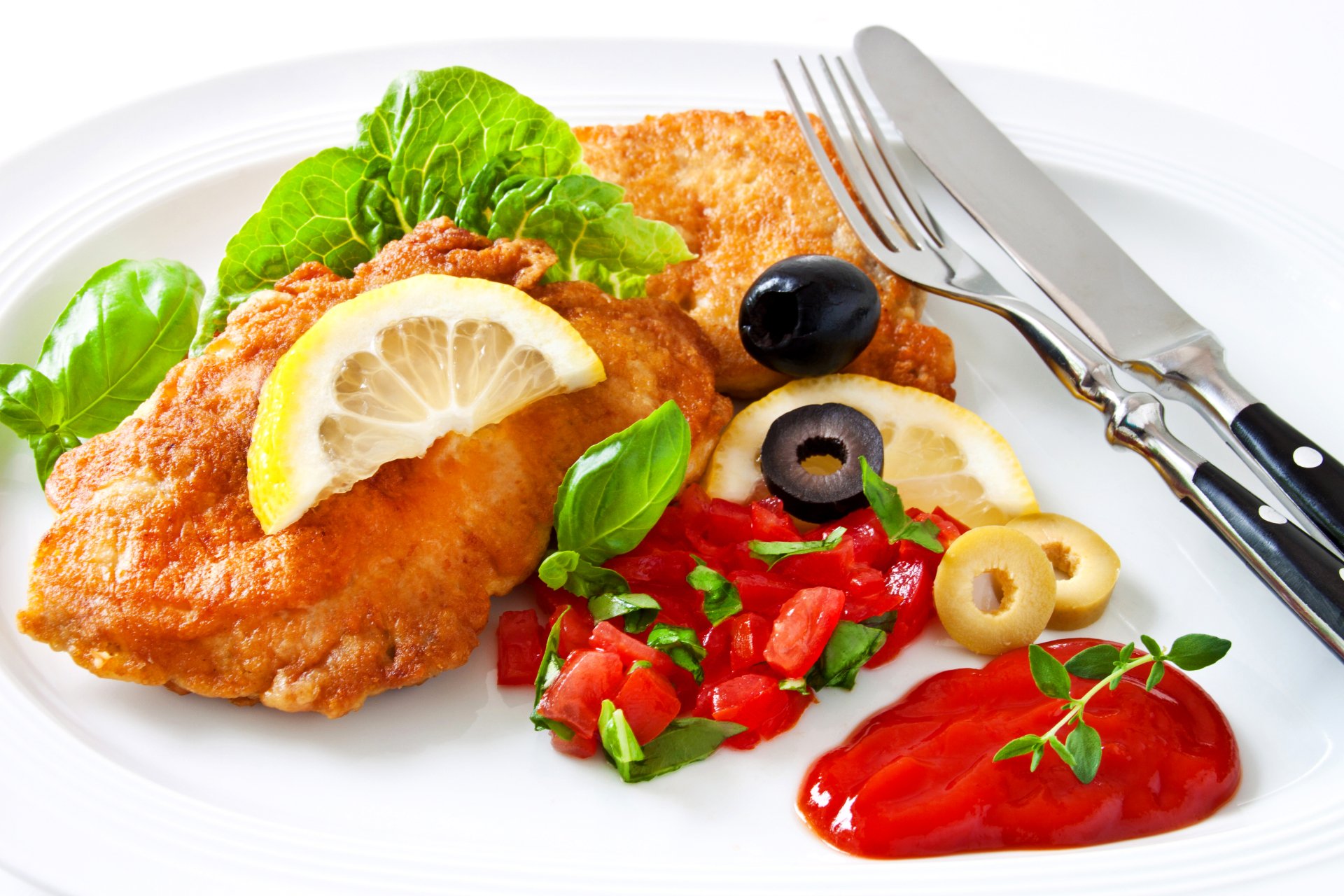 A vibrant 4K Ultra HD desktop wallpaper featuring a meal of breaded meat garnished with lemon, fresh vegetables, olives, and a dollop of ketchup on a white plate.