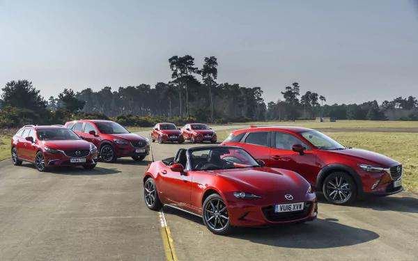 A lineup of red Mazda cars displayed on a runway under a clear sky, captured in 4K Ultra HD as a PC desktop wallpaper and background.