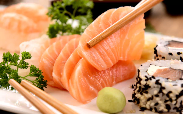 A vibrant display of fresh sashimi and sushi, garnished with wasabi and parsley, showcasing an appetizing seafood meal. This image serves as a stunning 4K Ultra HD desktop wallpaper.