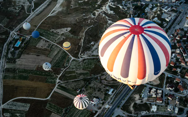 Aerial view of colorful hot air balloons floating over a rural and suburban landscape, captured in 4K Ultra HD as a PC desktop wallpaper and background.