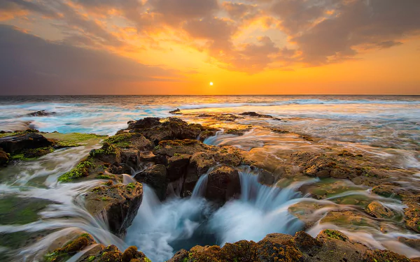HD PC desktop wallpaper and background: golden sunset over ocean horizon, waves rushing into Thor's Well amid rocky tidepools, vivid sky reflecting on glistening water.