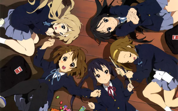 HD anime desktop wallpaper featuring the K-ON! girls lying in a circle, dressed in school uniforms against a wooden floor background.