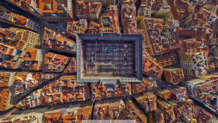 Aerial cityscape of Madrid, Spain centered on La Plaza Mayor, a rectangular plaza surrounded by dense historic buildings — HD PC desktop wallpaper background highlighting man-made urban geometry.