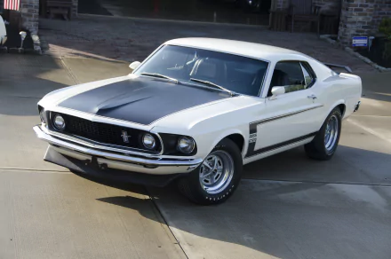 White 1969 Ford Mustang Boss 302 muscle car with black hood stripe parked on a driveway — HD desktop wallpaper/background.