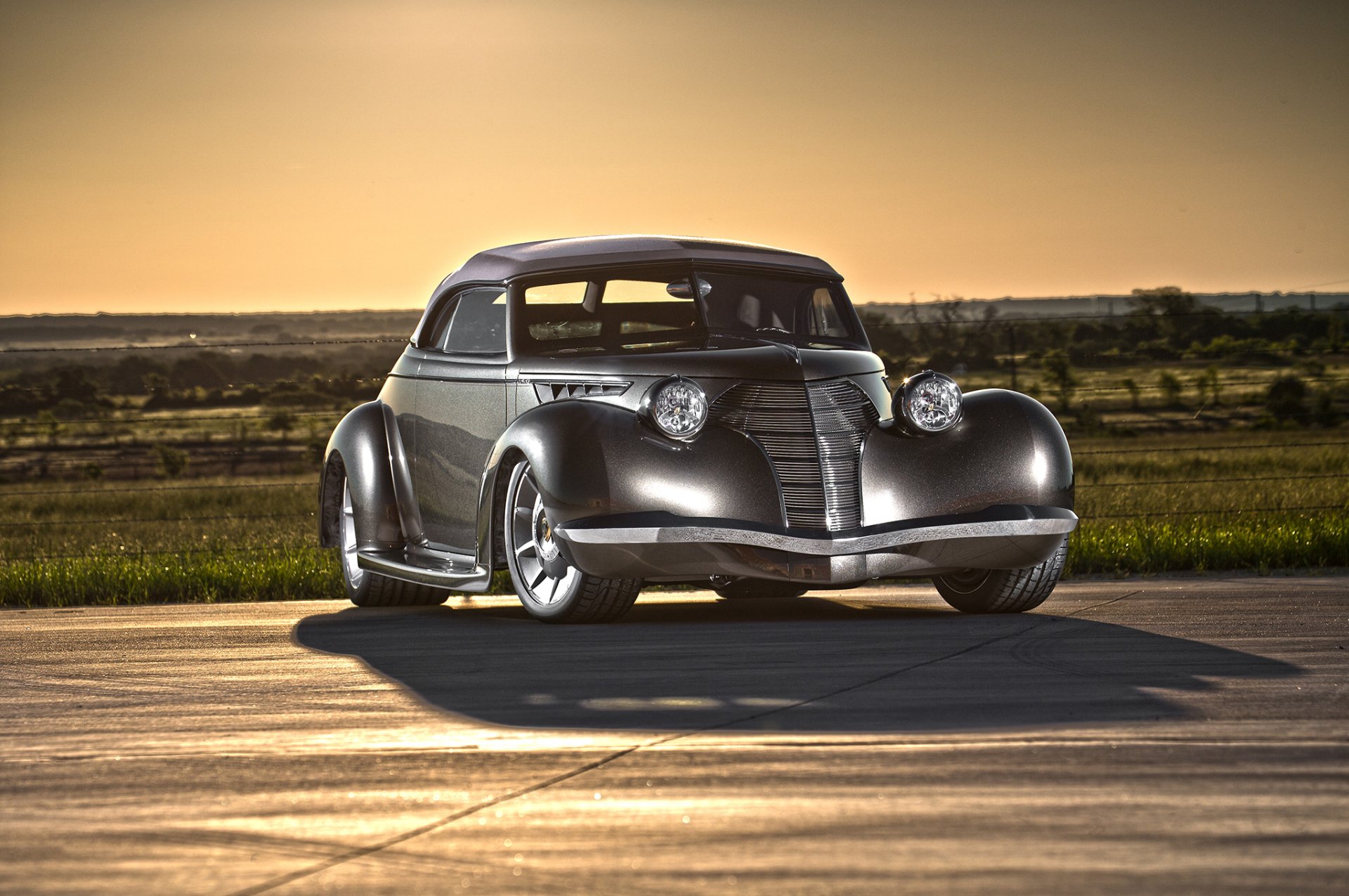 Sleek metallic 1939 Oldsmobile hot rod parked on a sunlit runway; vintage car HD PC desktop wallpaper and background.