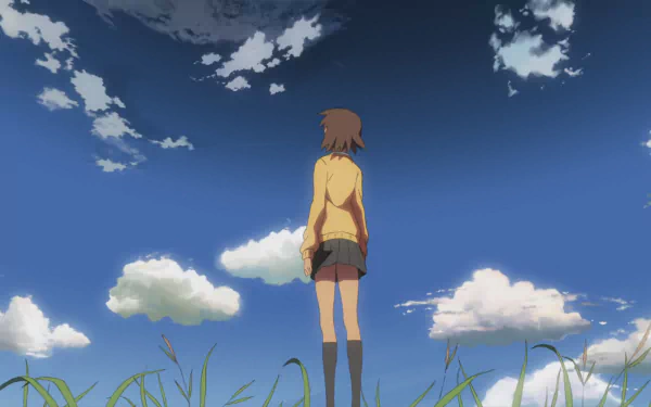 Anime wallpaper featuring Akari Shinohara from 5 Centimeters per Second standing in a grassy field under a vivid blue sky with scattered clouds, in HD quality.