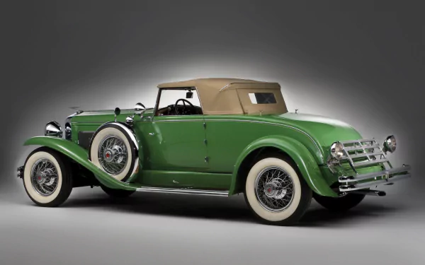 Green 1929 Duesenberg Model J Convertible Coupe vintage car against a neutral backdrop — HD desktop wallpaper of a classic luxury vehicle.