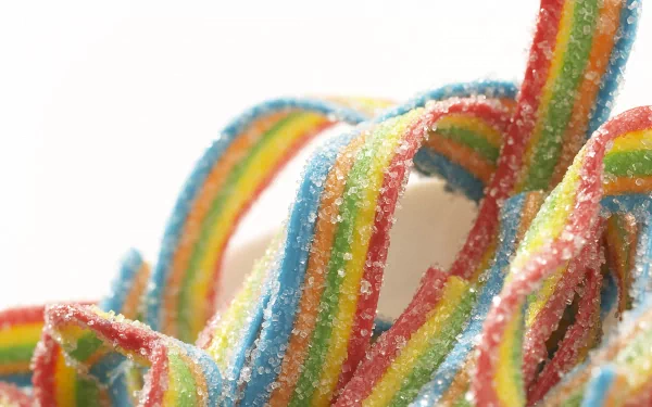 Colorful, sugary candy strips in vibrant hues of red, blue, yellow, and green, creating a fun and enticing background for your HD desktop wallpaper.