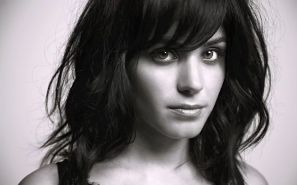 Black-and-white 5K desktop wallpaper: close-up portrait of a brunette woman's face with intense eyes and a moody, music-inspired aesthetic.