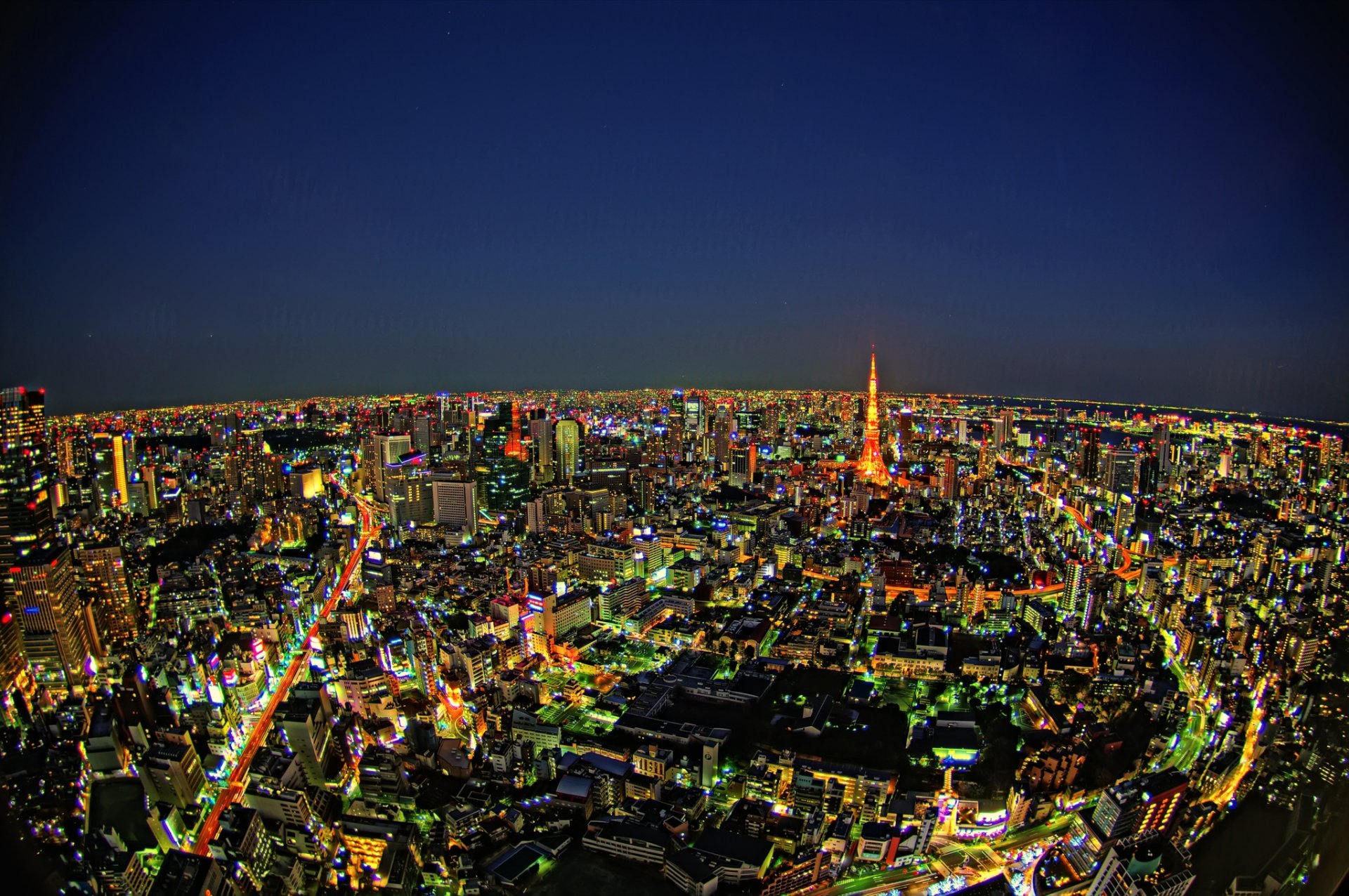 A stunning HD wallpaper showcasing the vibrant night skyline of Tokyo, Japan, illuminated by countless lights and featuring the iconic Tokyo Tower amidst a bustling urban landscape.