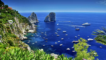 A stunning view of Capri, Italy, showcasing the vibrant blue sea with boats scattered across the water, framed by lush greenery and iconic rocky cliffs against a clear horizon.