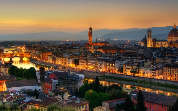 Nighttime cityscape of Florence, Italy, showcasing illuminated buildings along the river with historic architecture under a sunset sky in this HD desktop wallpaper.