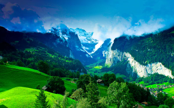 A stunning 4K Ultra HD landscape of a lush green valley nestled between forested mountains under a bright blue sky with scattered clouds.