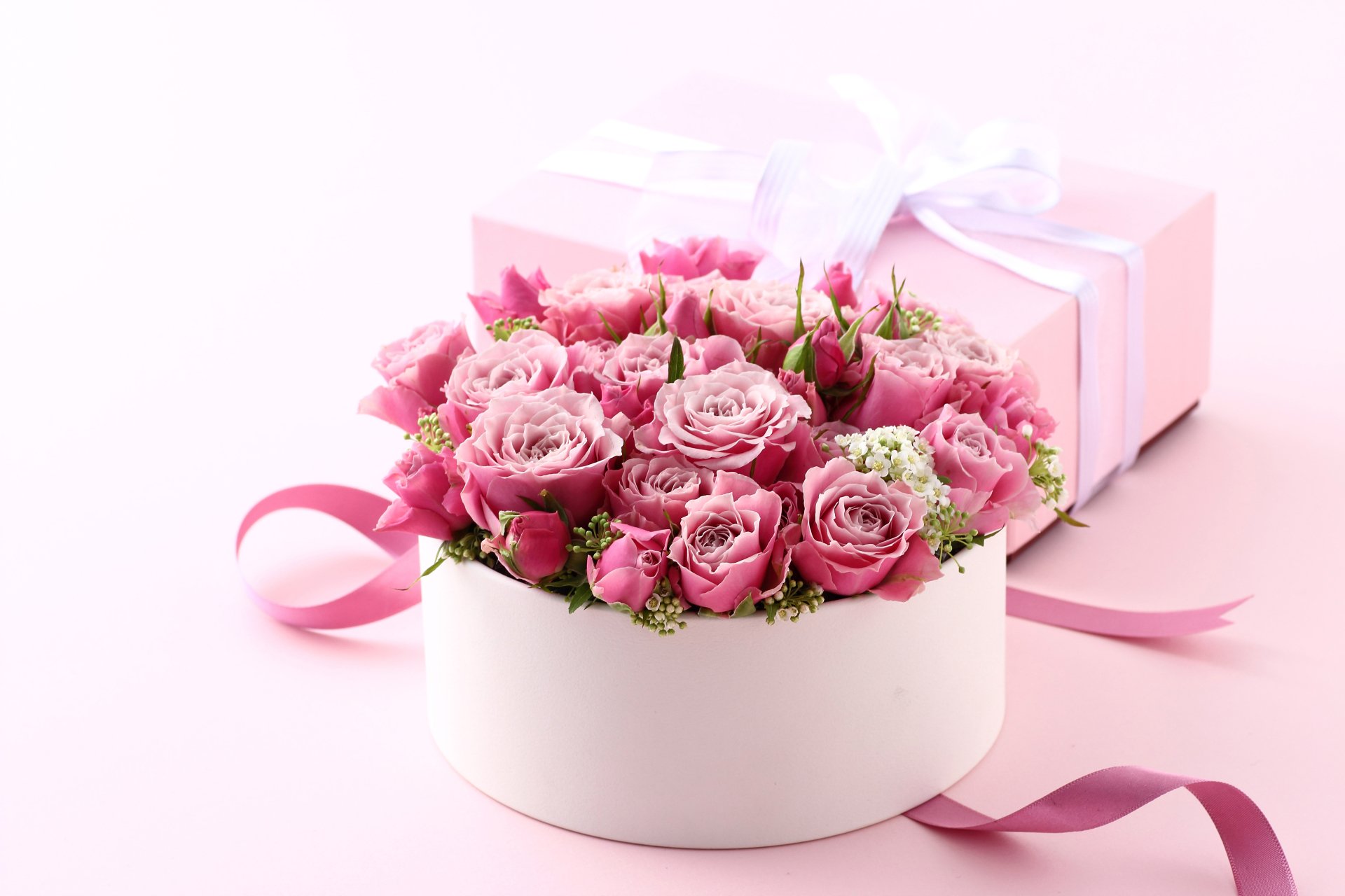 A 4K Ultra HD desktop wallpaper featuring a round white box filled with pink roses, a pink ribbon, and a pink gift box, evoking Valentine's Day and holiday themes.