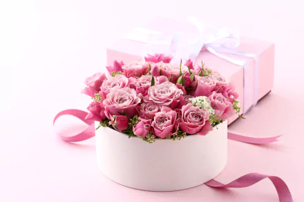 A 4K Ultra HD desktop wallpaper featuring a round white box filled with pink roses, a pink ribbon, and a pink gift box, evoking Valentine's Day and holiday themes.