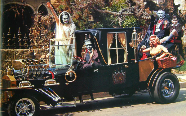 Lily Munster, Herman Munster, and family pose in their classic car for a Halloween-themed HD desktop wallpaper from the TV show The Munsters.