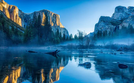 HD desktop wallpaper of Yosemite National Park at dawn, featuring a serene lake reflection of mountains and trees under a clear blue sky.
