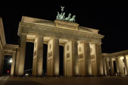 The Brandenburg Gate illuminated at night in Berlin, a stunning man-made monument showcasing Germany's architectural beauty. An impressive HD desktop wallpaper.