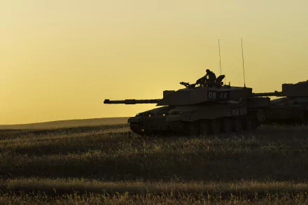 HD desktop wallpaper featuring a silhouette of a Challenger 2 military tank against a sunset sky in an open field.