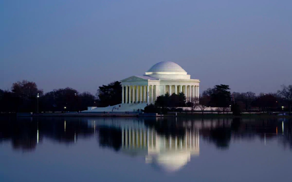 Twilight view of the historic Thomas Jefferson Memorial in Washington, USA, with its dome and architecture reflected in the calm lake water.