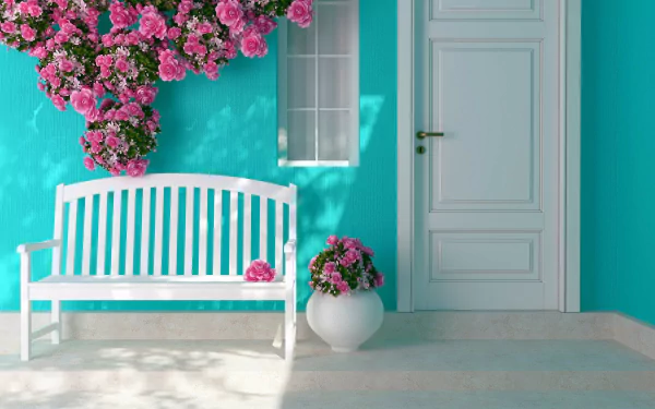 A serene scene featuring a white bench against a vibrant teal wall, adorned with blooming pink roses, complemented by a white door and a floral vase.