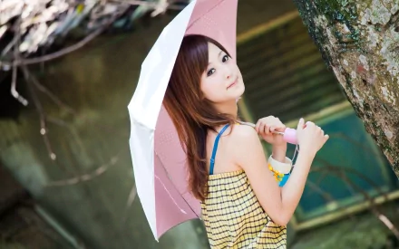 HD desktop wallpaper featuring an Asian woman, tagged as Mikako Zhang Kaijie, holding a pink umbrella and standing by a tree in a natural outdoor setting.
