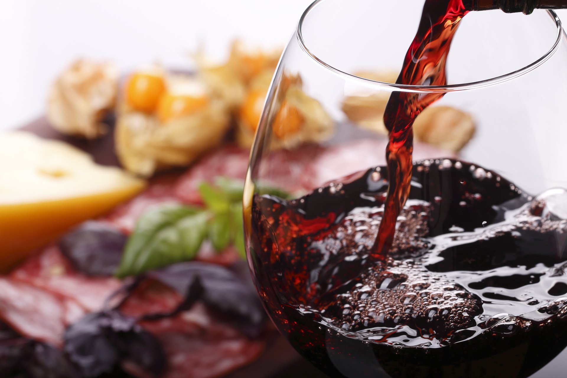 5K Ultra HD PC desktop wallpaper and background: red wine pouring into a glass beside cheese, cured meats and herbs — a crisp food and wine still life.