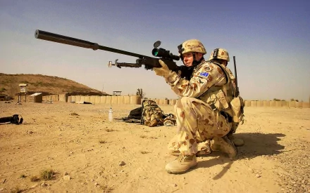 HD desktop wallpaper depicting an Australian military sniper in uniform, aiming through a rifle with a scope in a desert environment.