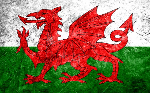 HD desktop wallpaper featuring the flag of Wales with a vibrant red dragon on a textured white and green background.