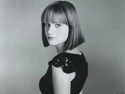 Black and white HD desktop wallpaper featuring celebrity Zooey Deschanel with a bob haircut, wearing a sleeveless black top, looking over her shoulder.