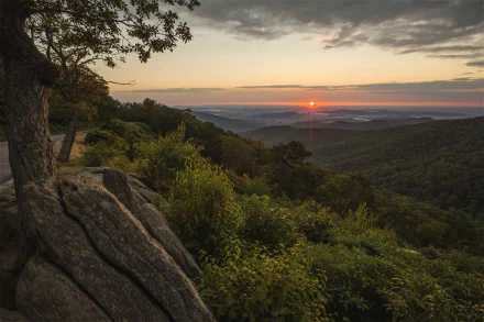 Sunrise over lush green hills and rocky terrain in Shenandoah National Park, Virginia, showcasing a scenic landscape in the USA.