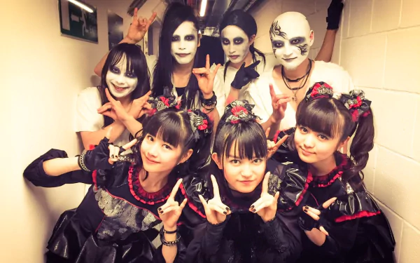 A vibrant HD wallpaper featuring the Japanese metal idol group Babymetal, showcasing their unique heavy metal style with members in striking outfits and bold makeup.