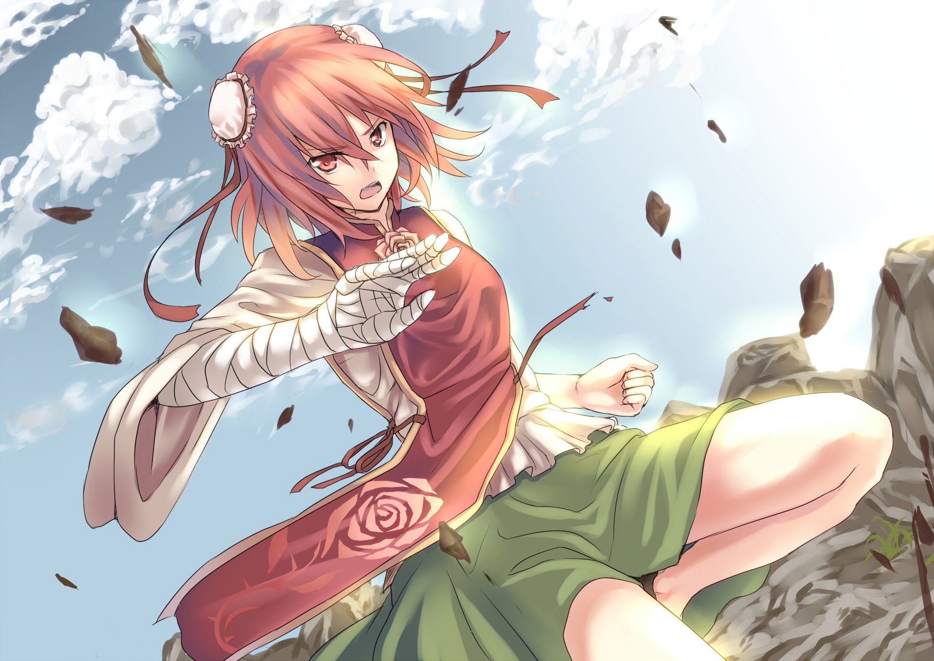 Kasen Ibaraki (Touhou) in a dynamic pose atop rocky cliffs, wind‑blown red hair, red top and green skirt, petals and debris against a bright sky — 2K Quad HD PC desktop wallpaper
