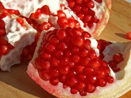 HD desktop wallpaper featuring vibrant, juicy pomegranate seeds nestled in white pith, highlighting the rich red color and texture of the fruit.